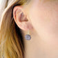 Purple-pink raw ruby stones suspended from sterling silver earwires. The stones are rough and in their natural hexagonal shape.  Modeled image.