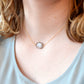 An irregular oval shape, smooth polished Smokey Quartz stone set onto a 14k gold filled chain. The stones edges are raw and irregular. Modeled image.