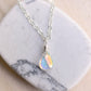 Rainbow Quartz teardrop crystal on a sterling silver chain. The stone flashes a shimmering array of rainbow colors. 