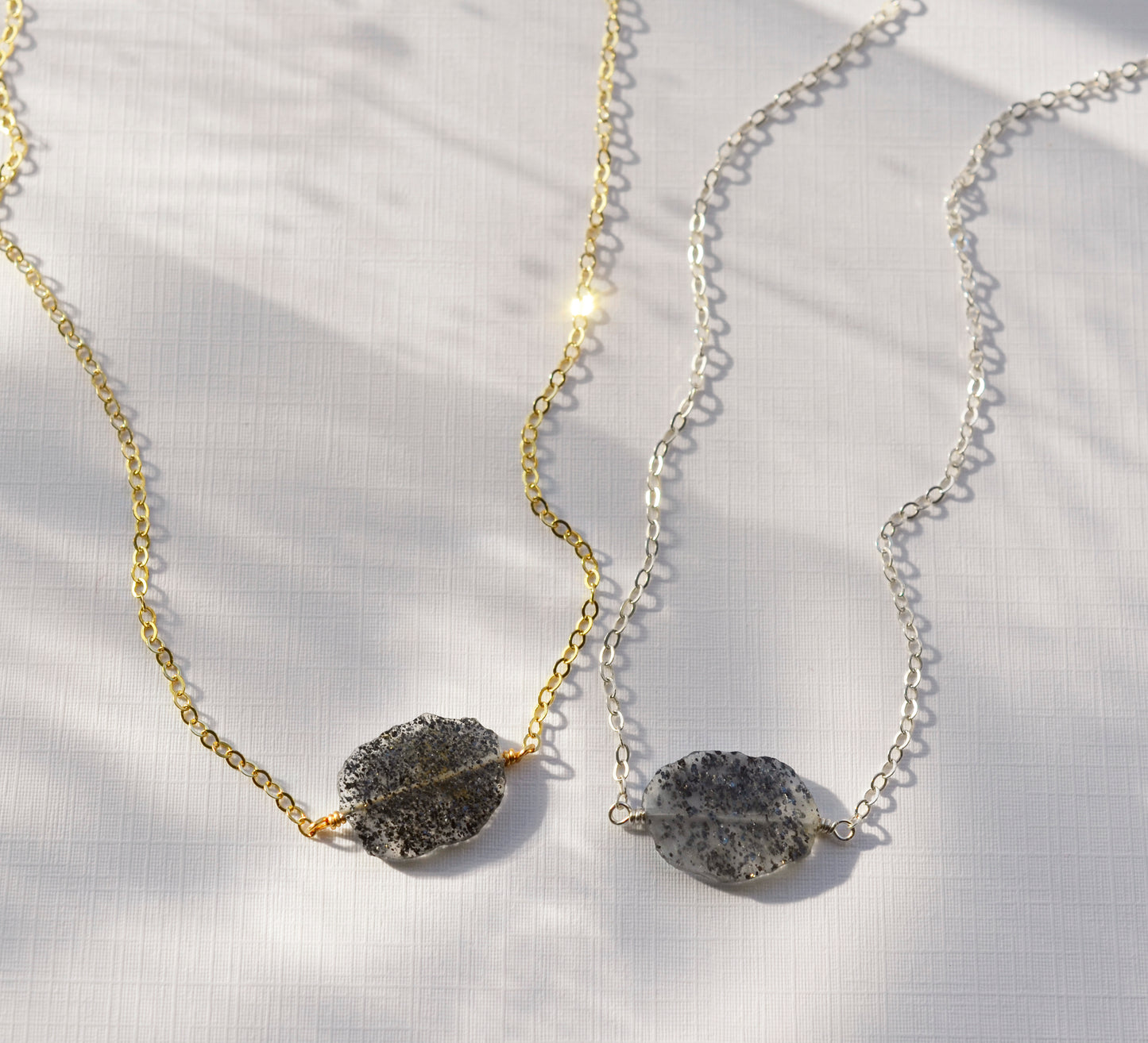 Black sunstone slice pendants shown on a sterling silver and a 14k gold filled chain.