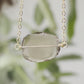 An irregular oval shape, smooth polished Smokey Quartz stone set onto a 14k gold filled chain. The stones edges are raw and irregular. Video.