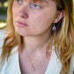 Rainbow Mystic Topaz dangle earrings. The stones are teardrop shaped. Modeled with matching necklace.