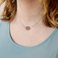 An irregular oval shape, smooth polished Smokey Quartz stone set onto a 14k gold filled chain. The stones edges are raw and irregular. Modeled image.